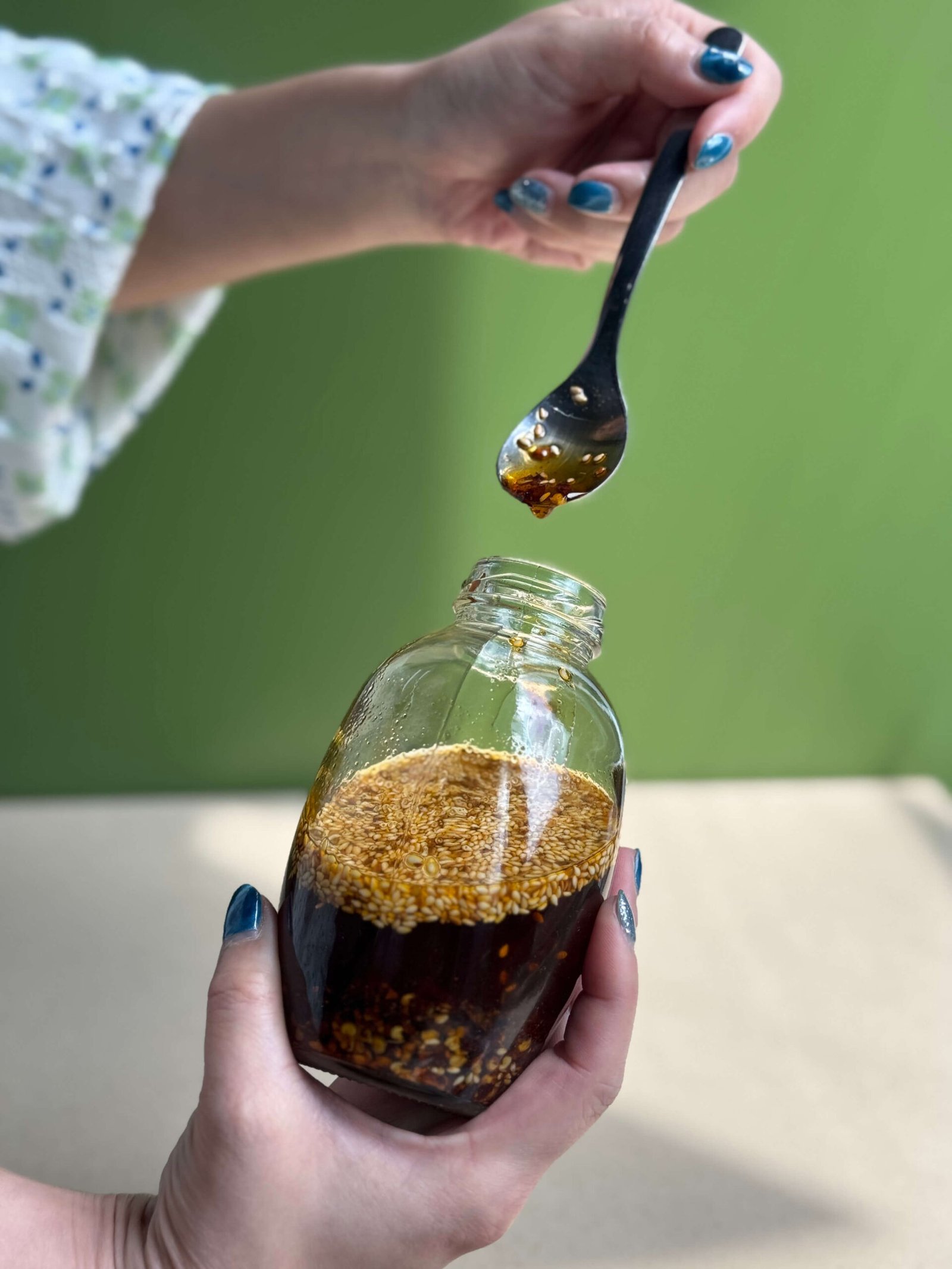 Vibrant, rich homemade chili oil being drizzled into a dipping dish